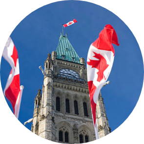 Image of Canada’s Parliament Hill with Canadian flag swinging in the wind