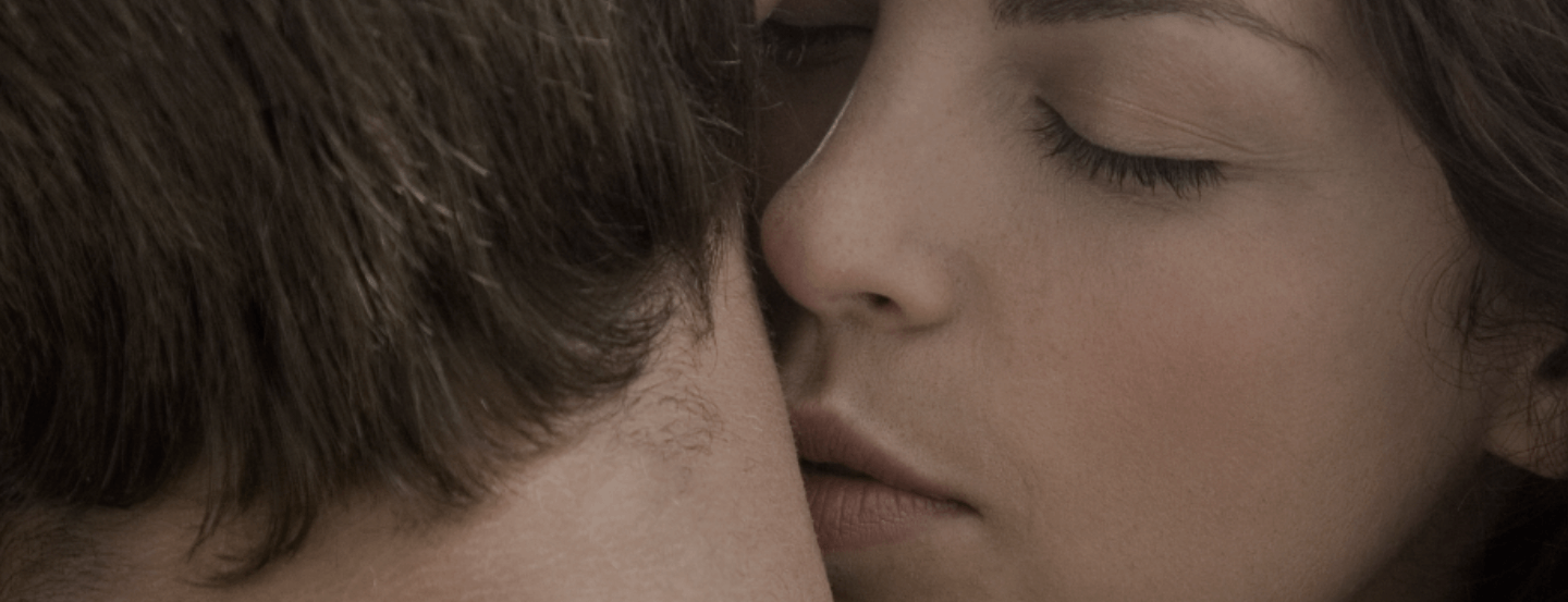 Close up of a woman kissing her partner’s neck
