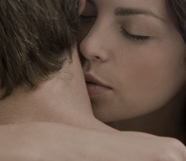 Close up of woman kissing her partner’s neck